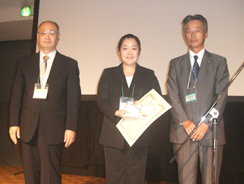 (写真右)受賞の由利啓子さん(中)、渋谷俊昭先生(左)、弊社福澤事業部長(右)