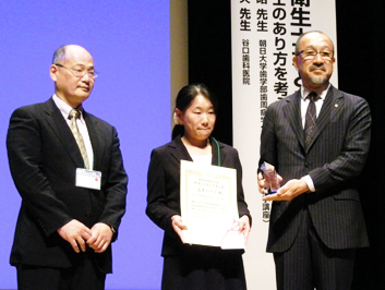 (写真左)受賞の山本やすよさん(中)、渋谷俊昭先生(左)